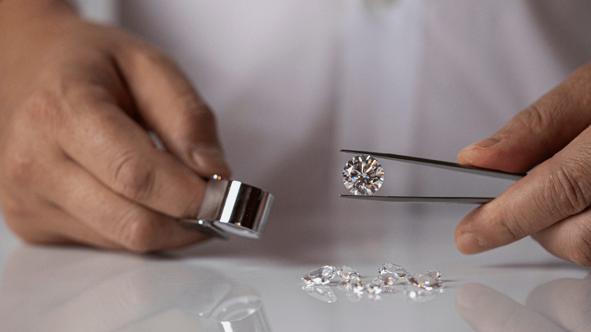 a scientist holds a diamond with tweezers in a lab