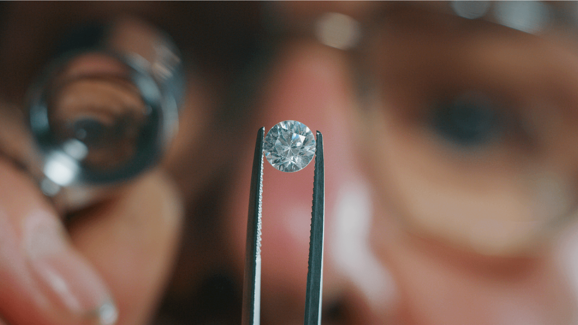 a scientist examines a diamond with tweezers in a lab