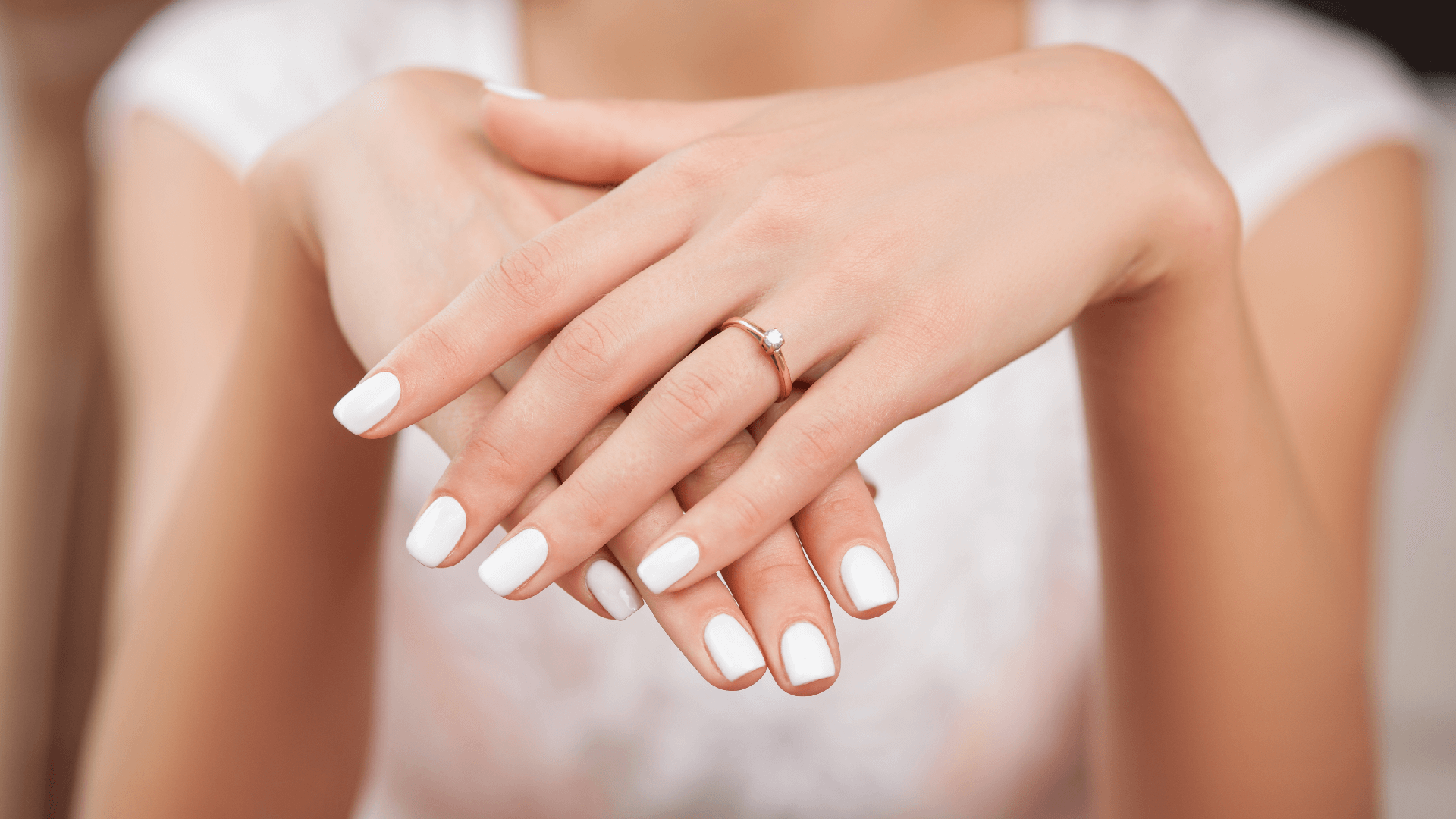 a woman shows off her diamond engagement ring