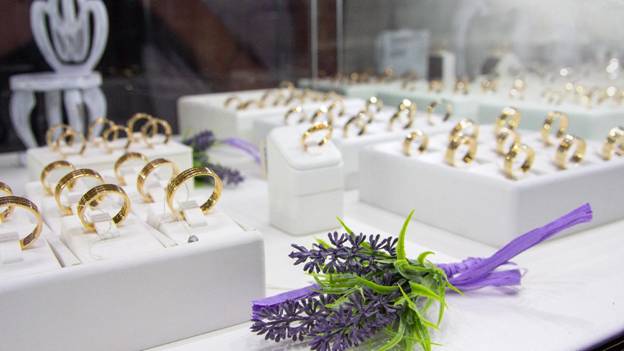 various types of wedding bands sit on a jewelry store counter