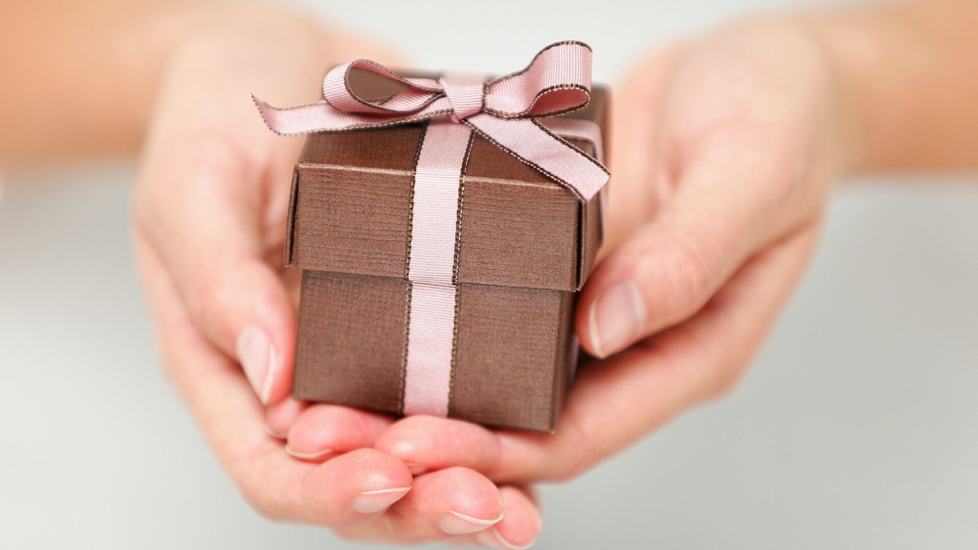 a small gift box sits in someone’s hands
