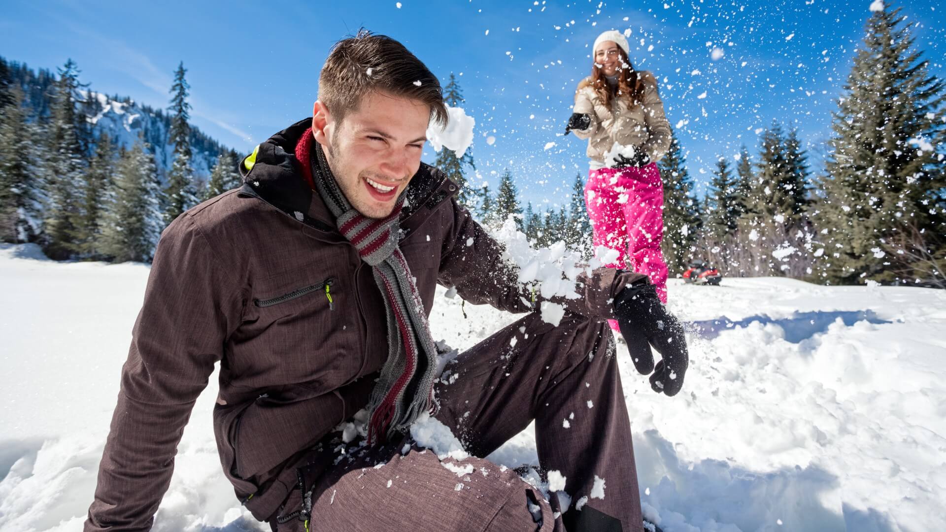 a couple has a snowball fight