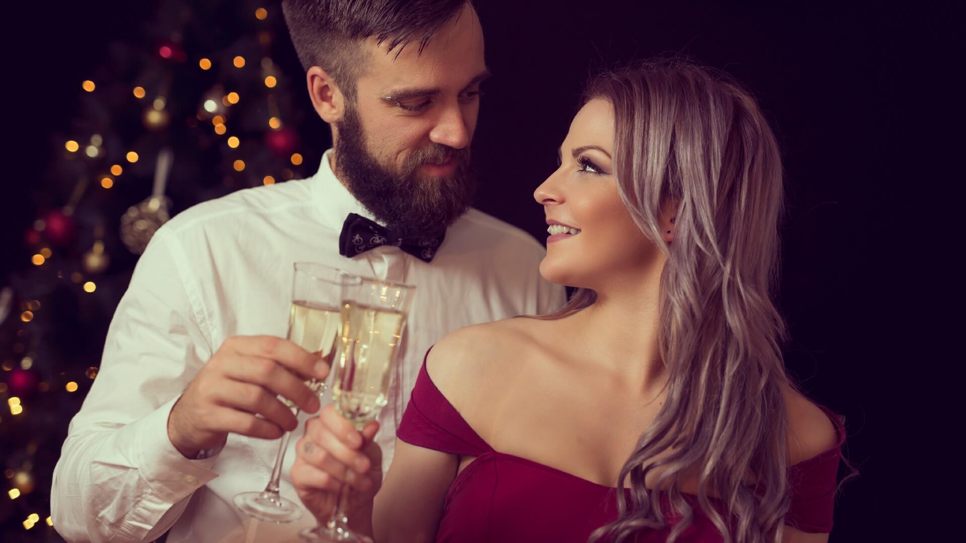 Couple is having a midnight toast with glasses of champagne during a Christmas celebration