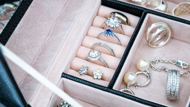 a box filled with rings and earrings shows customers about storing jewelry properly
