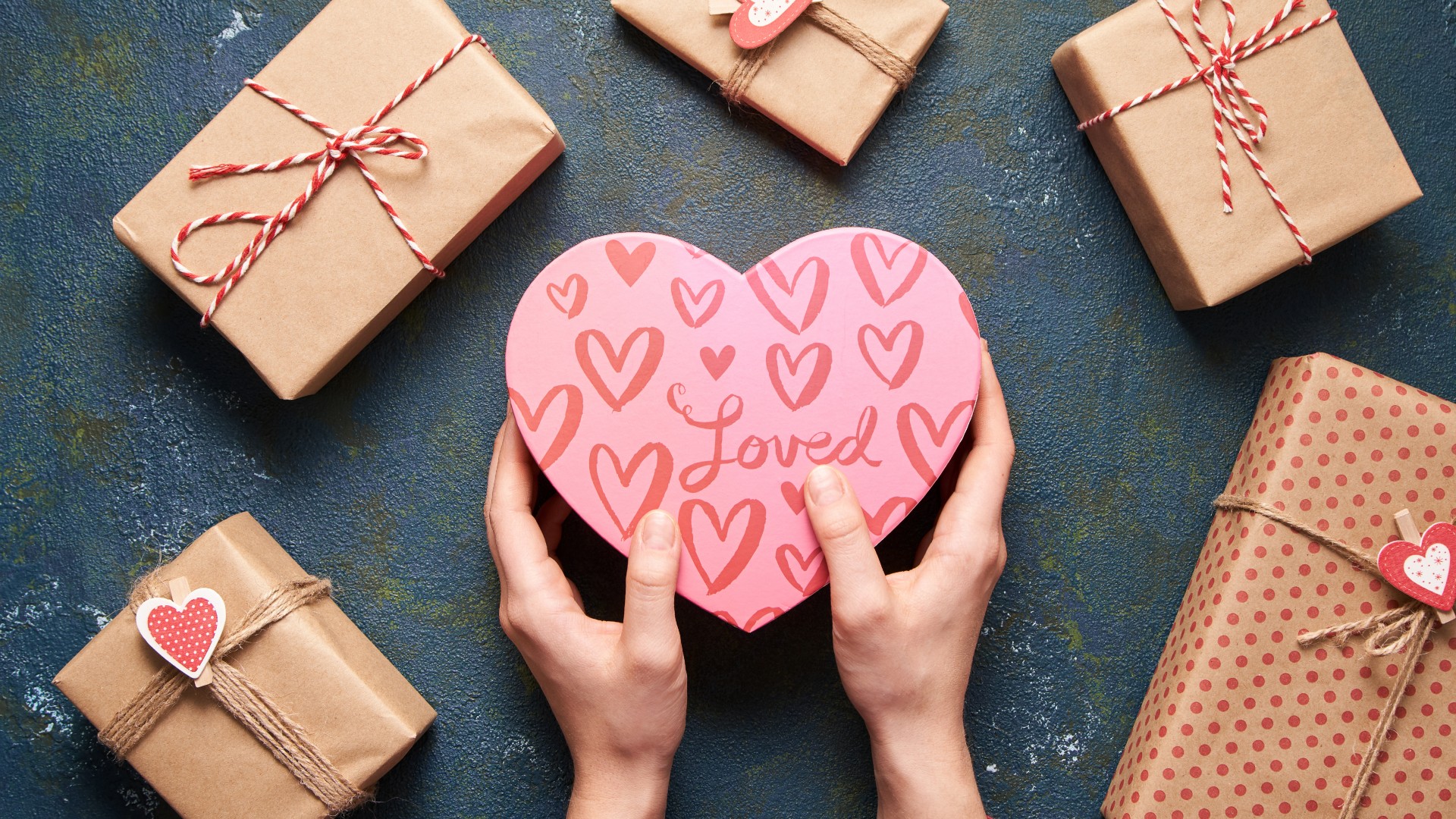 Valentine’s Day Gift Guide: a person’s hands holding a heart-shaped box