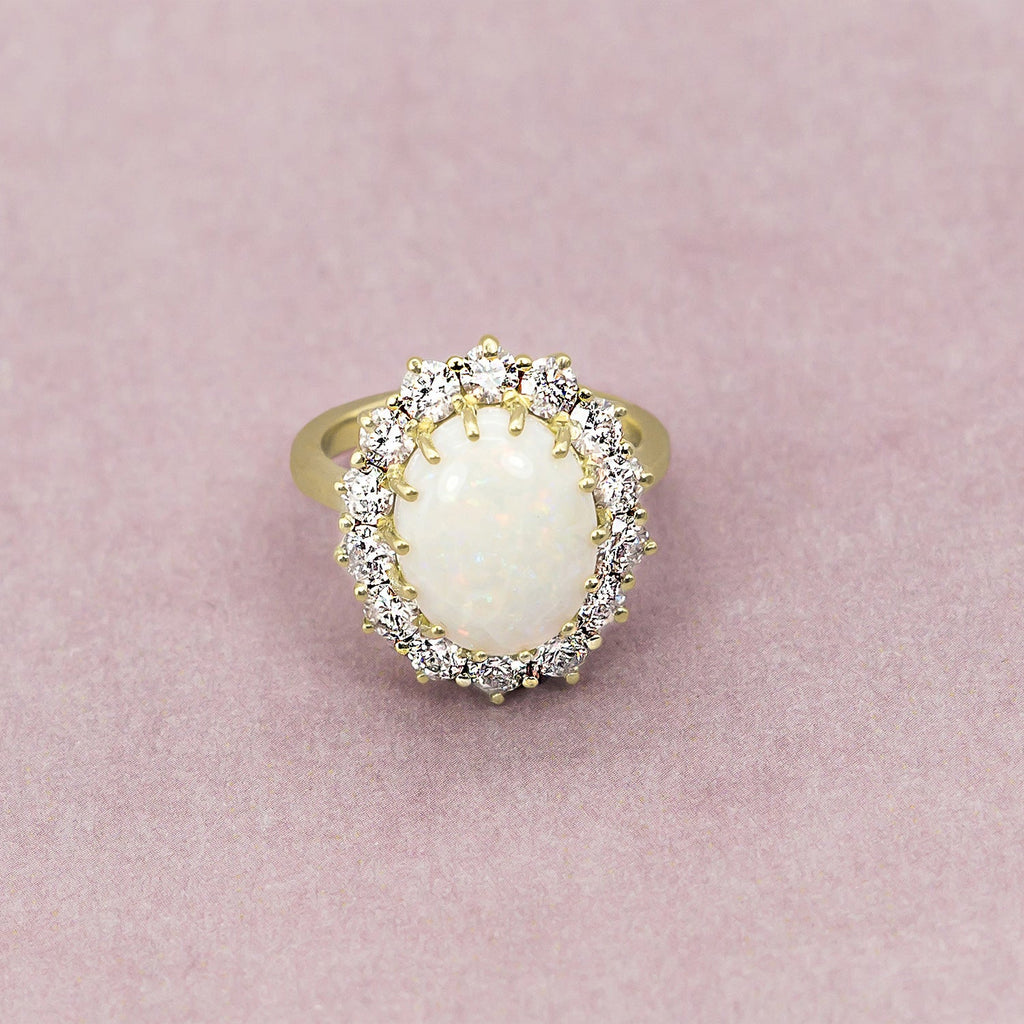 Natural oval opal and fourteen white diamond halo Lady Di ring in yellow gold, original close-up product photograph
