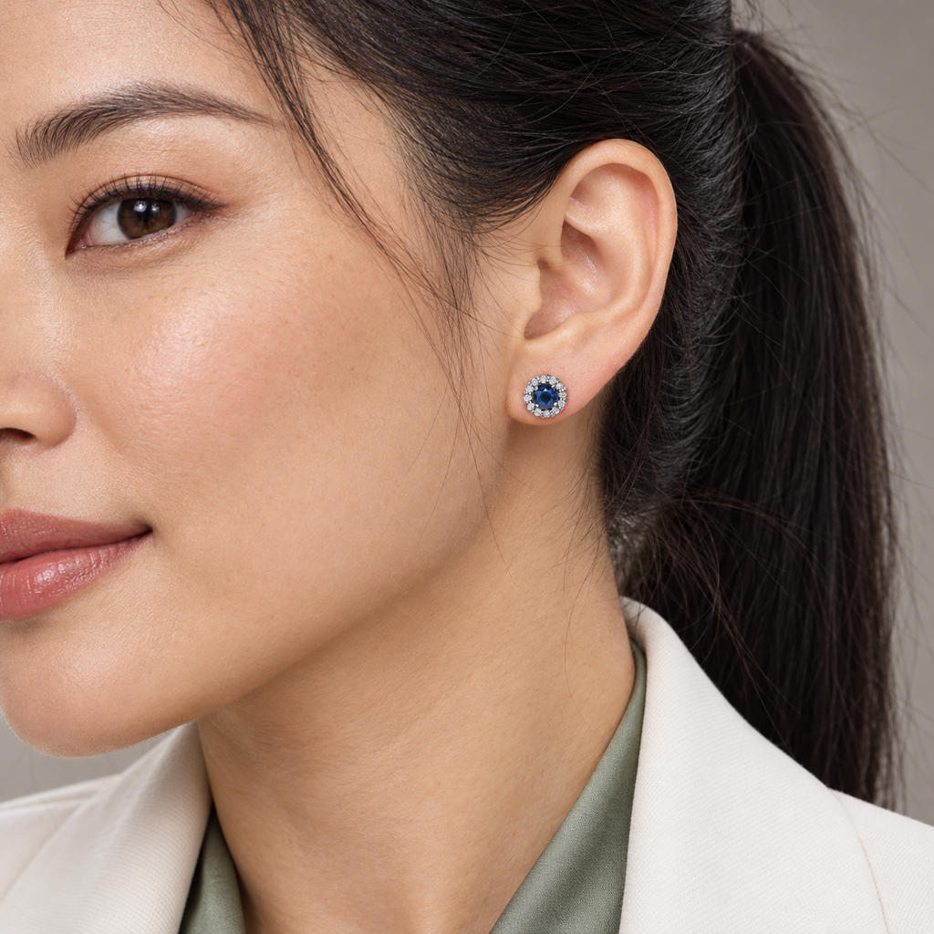 Natural blue sapphire diamond halo stud earrings — close-up ear model, 6.16 mm studs
