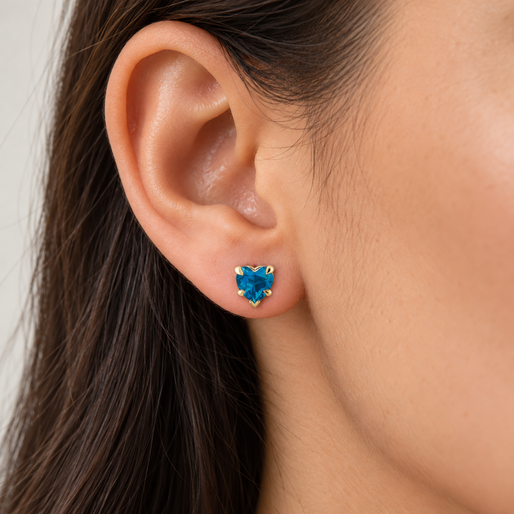 Heart natural blue topaz stud earrings 14K yellow gold — close-up model