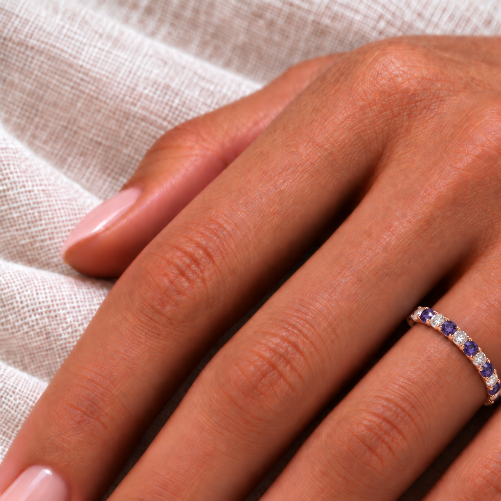 AZ10713 2.5 mm purple lab-created alexandrite and natural diamond eternity band in 14k rose gold on left hand over ivory linen