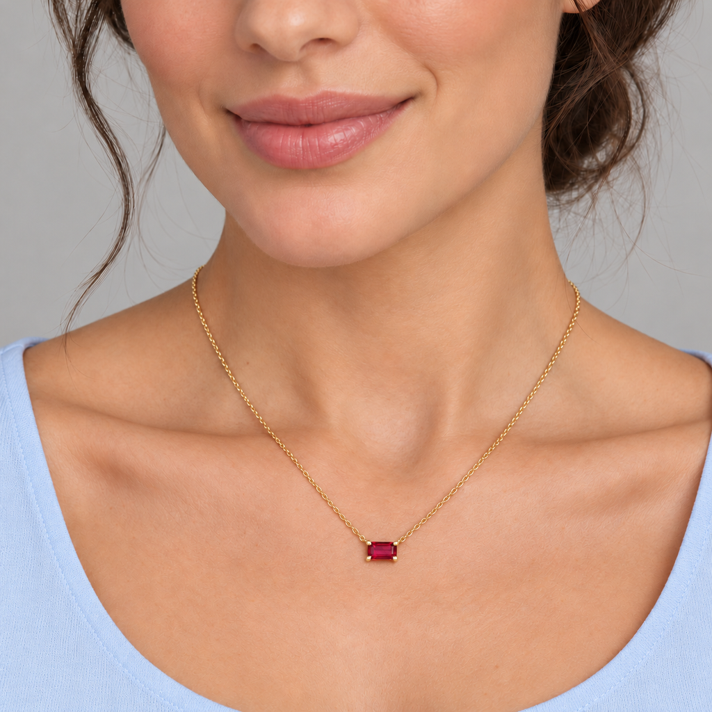 AZ29481 — close-up model wearing 5 × 3 mm emerald-cut lab-grown ruby solitaire necklace in 14K yellow gold on an 18-inch cable chain; illustrative scale.