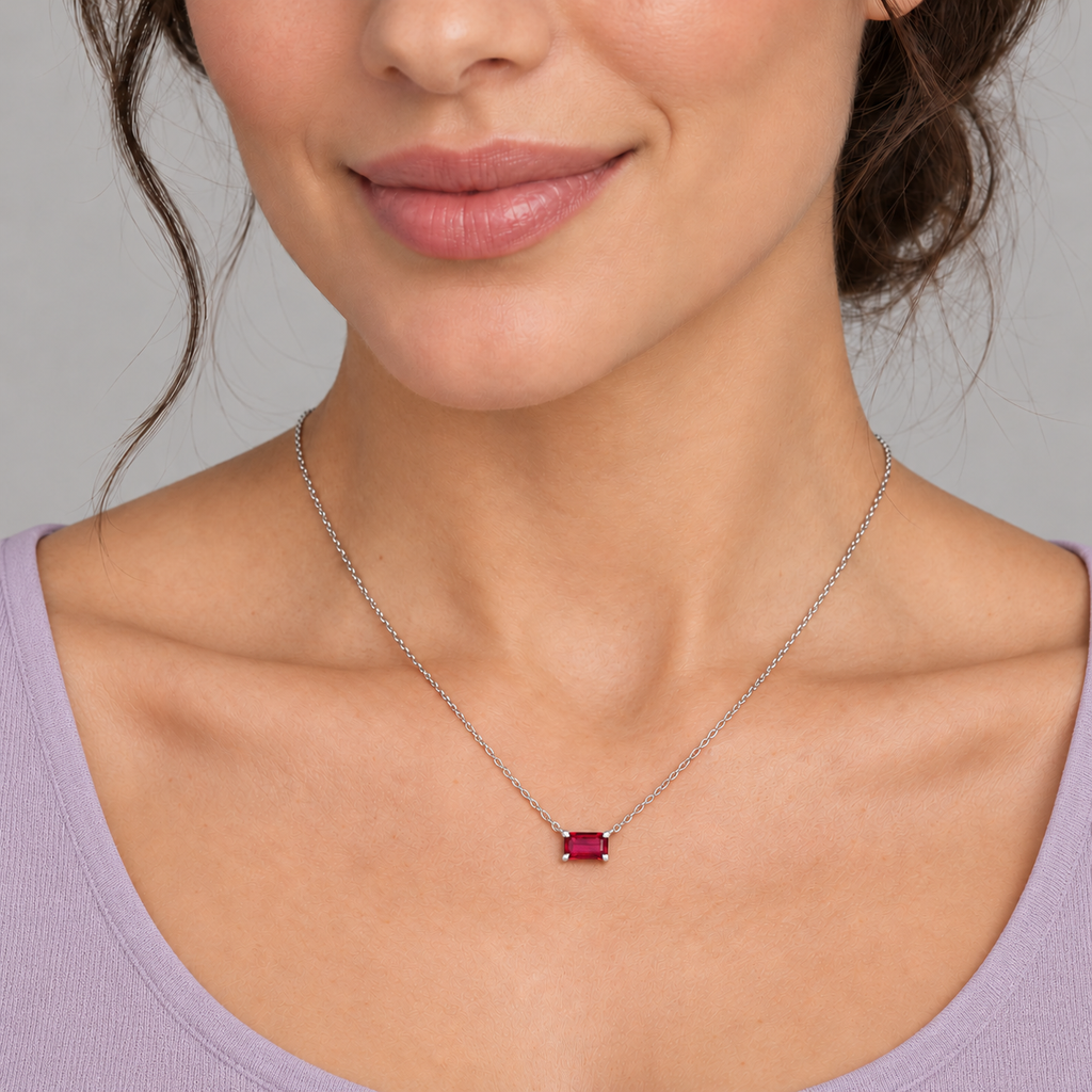 AZ29482 — close-up model wearing 5 × 3 mm emerald-cut lab-grown ruby solitaire necklace in sterling silver on an 18-inch cable chain; illustrative scale.