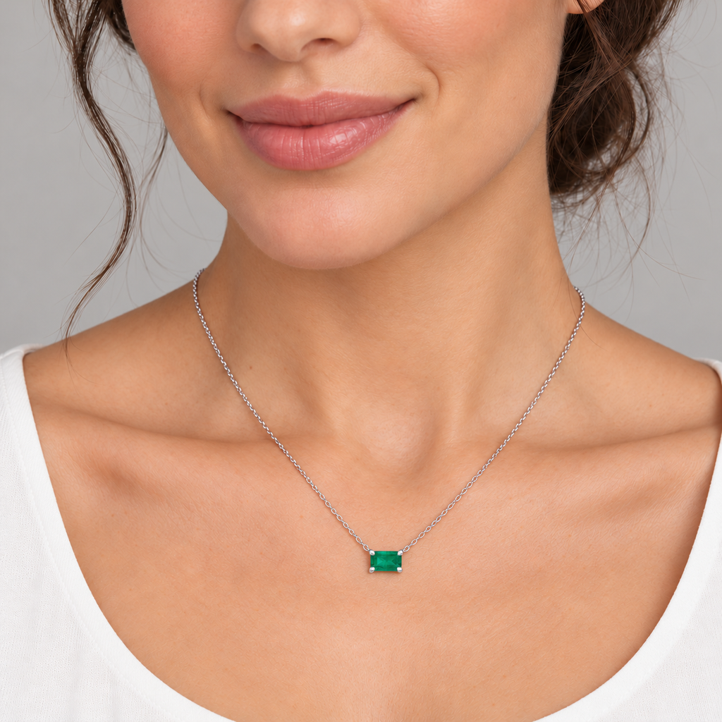 AZ29483 — close-up model wearing 5 × 3 mm emerald-cut lab-grown emerald solitaire necklace in 14K white gold on an 18-inch cable chain; illustrative scale.