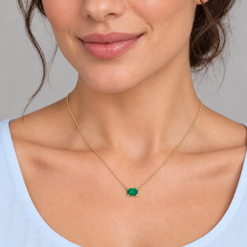 AZ29484 — close-up model wearing 5 × 3 mm emerald-cut lab-grown emerald solitaire necklace in 14K yellow gold on an 18-inch cable chain; illustrative scale.