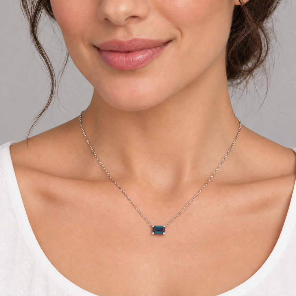 AZ29489 — close-up model wearing 5 × 3 mm emerald-cut lab-grown alexandrite solitaire necklace in 14K white gold on an 18-inch cable chain; illustrative scale.
