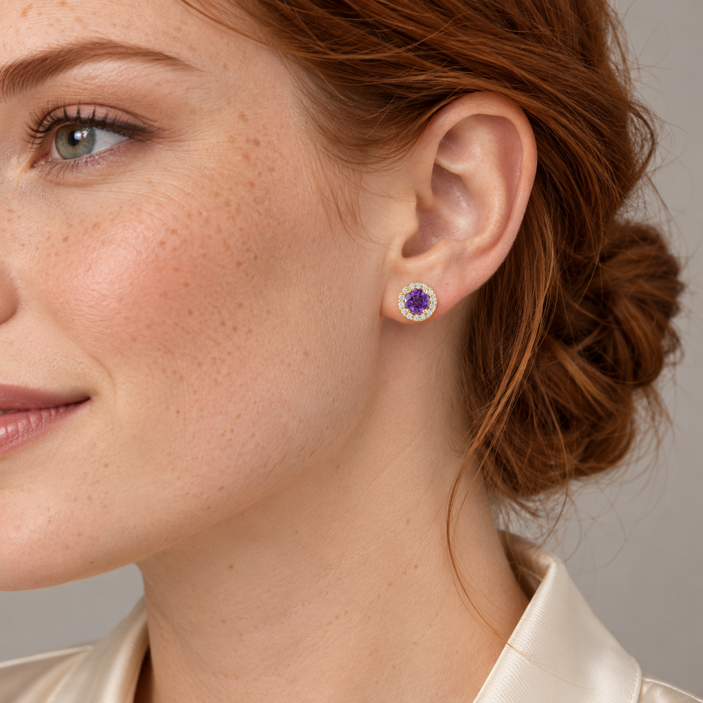 Close-up model wearing natural amethyst and diamond halo stud earrings in 14K Yellow Gold