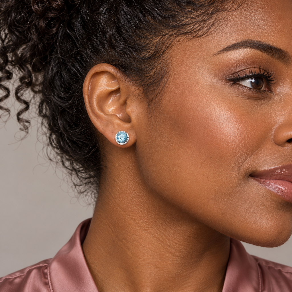 Close-up model wearing natural aquamarine and diamond halo stud earrings in 14K White Gold