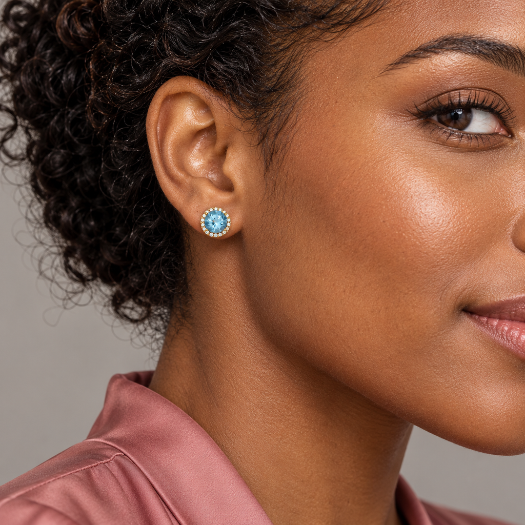 Close-up model wearing natural aquamarine and diamond halo stud earrings in 14K Yellow Gold