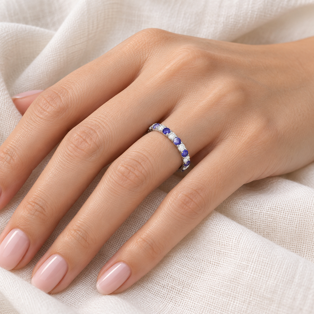 Diamond and tanzanite eternity band in 14k white gold on left hand, ivory linen closeup