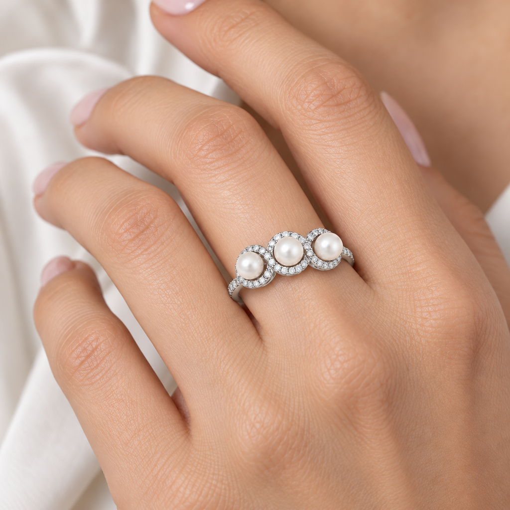 Freshwater three-pearl diamond halo ring in 14k white gold shown on a hand, with swirl detailing and a single row of diamonds on the band