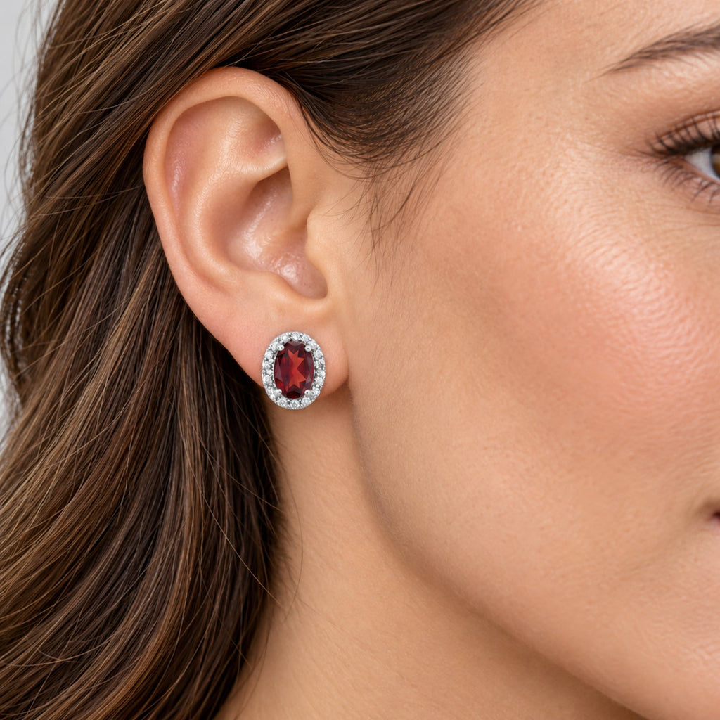 Oval Lab Garnet & Lab Diamond Halo Stud Earrings 14K White Gold 1.12ct, close-up model view