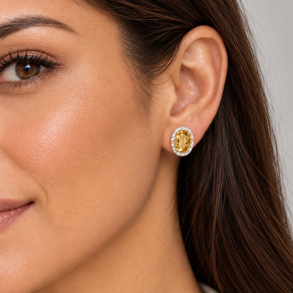 Close-up model wearing oval citrine studs, 7x5mm centers, yellow gold