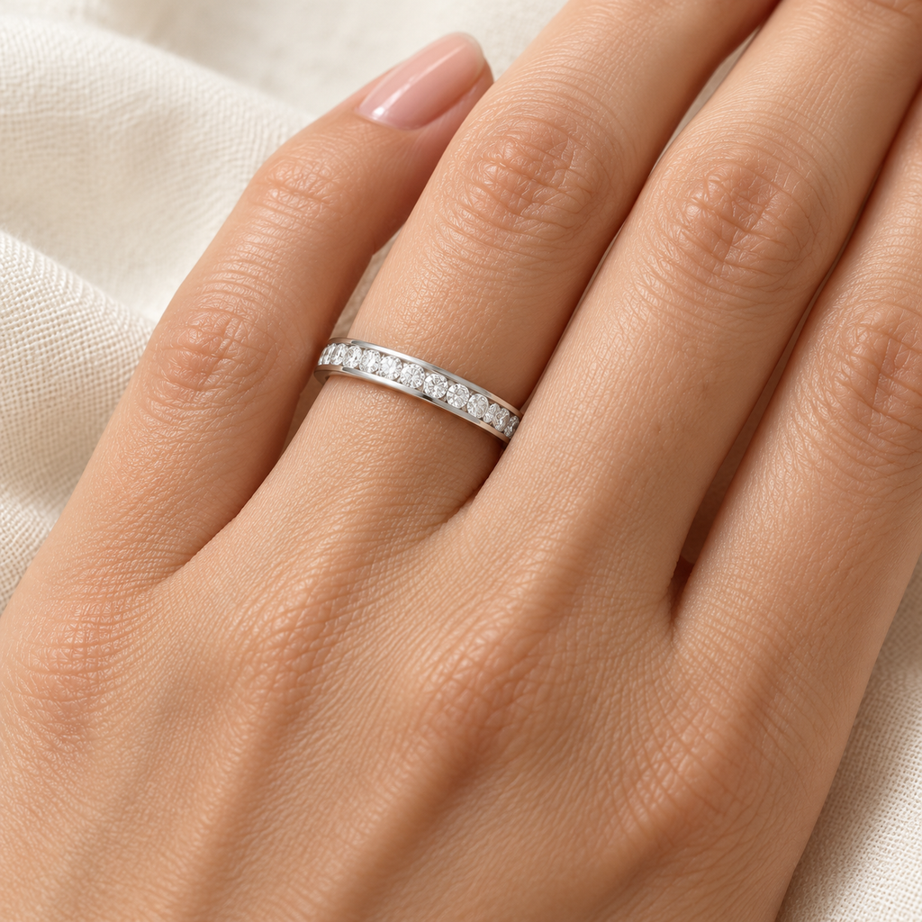 Diamond channel-set eternity band in palladium on left ring finger, ivory linen closeup
