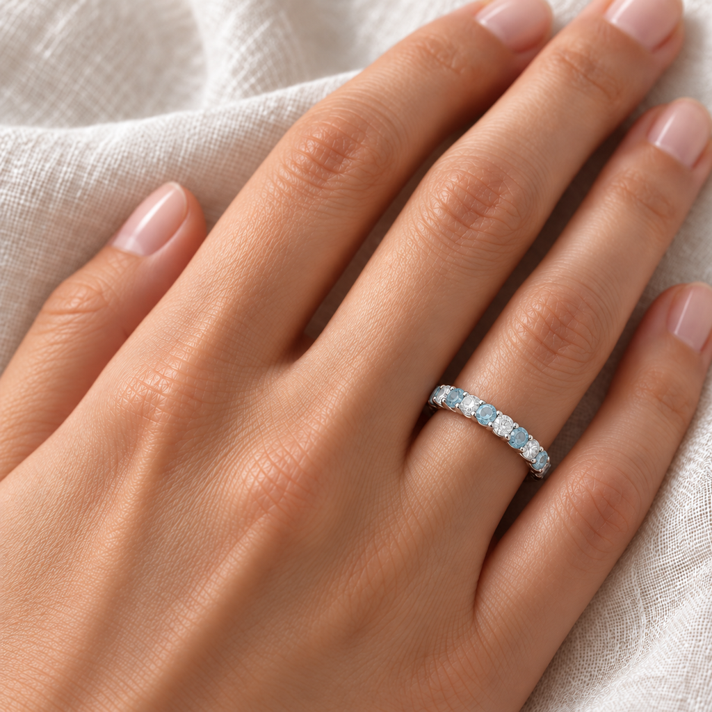 Lab-grown aquamarine and lab diamond eternity ring on left ring finger
