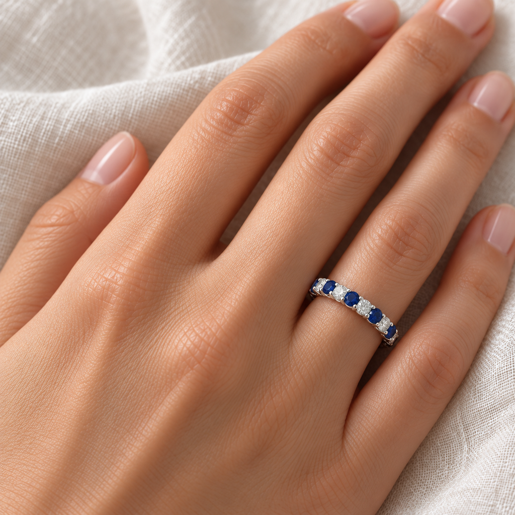 Blue sapphire and diamond eternity ring on left ring finger