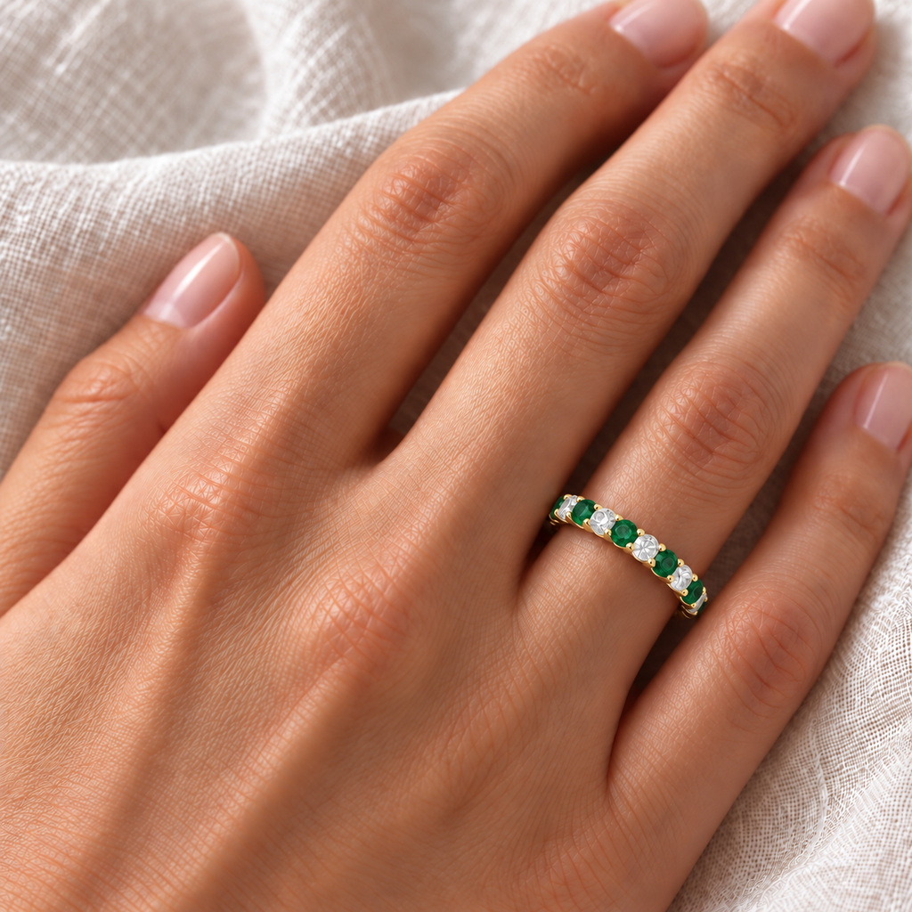 Emerald and diamond eternity ring on left ring finger