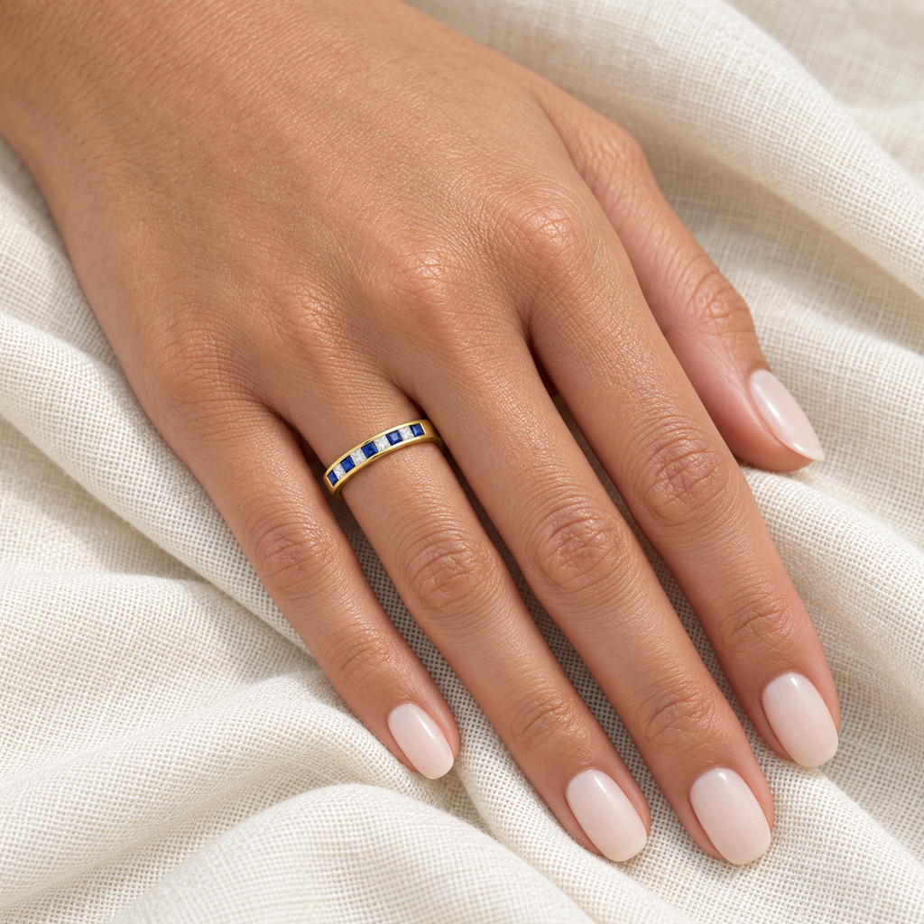 Princess-cut lab sapphire and lab-grown diamond channel-set band in 14K yellow gold, 4mm, 0.73ctw — ivory-linen left-hand closeup