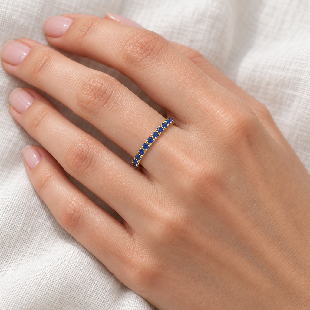 Blue Sapphire Eternity Band Anniversary Ring 14K Yellow Gold (0.50ct) — ivory linen close-up on left hand