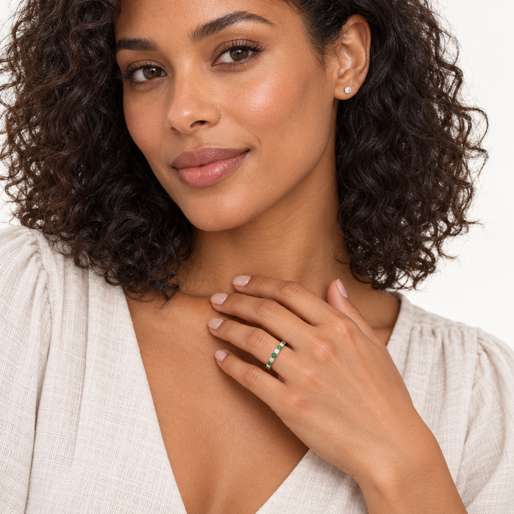 Lab-grown emerald and lab-grown diamond 14K rose gold eternity band worn in professional studio portrait