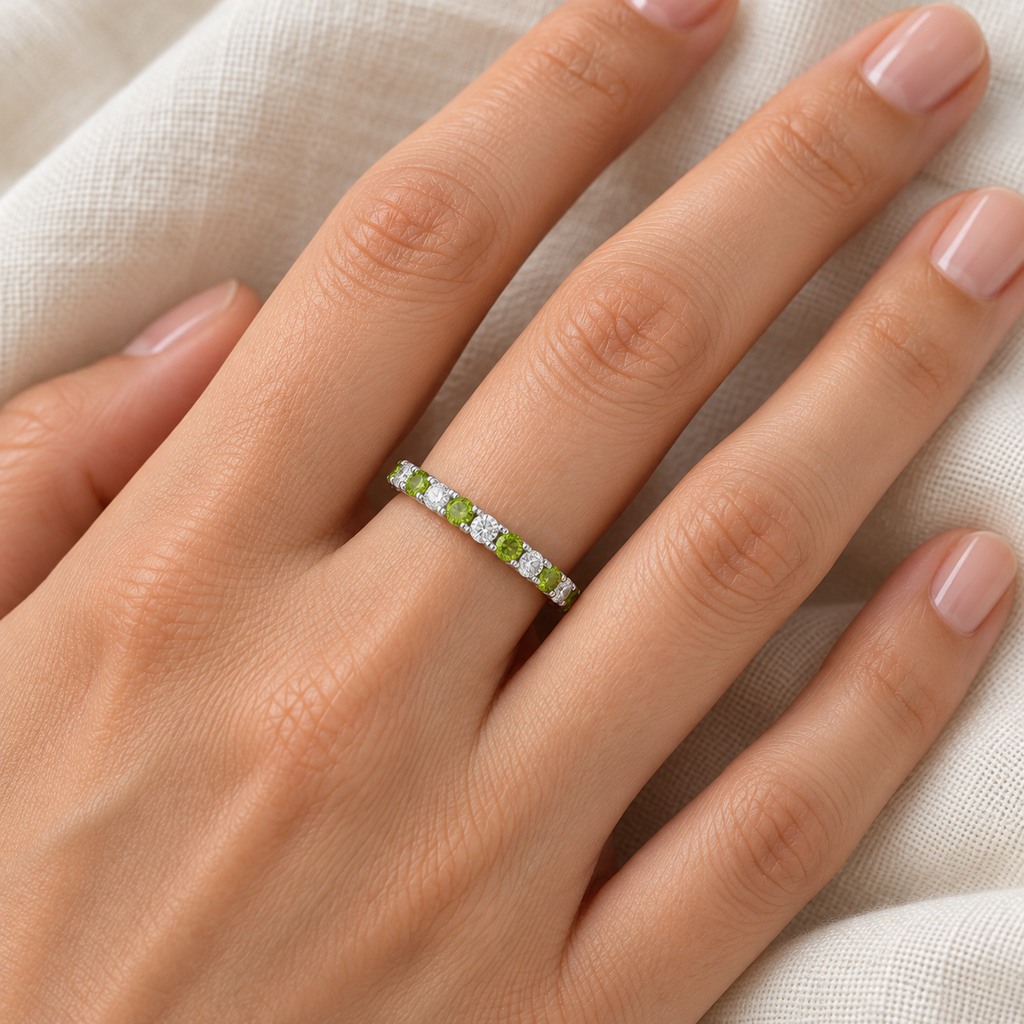 Peridot and diamond 14K white gold 2 mm eternity band on left hand, ivory linen closeup