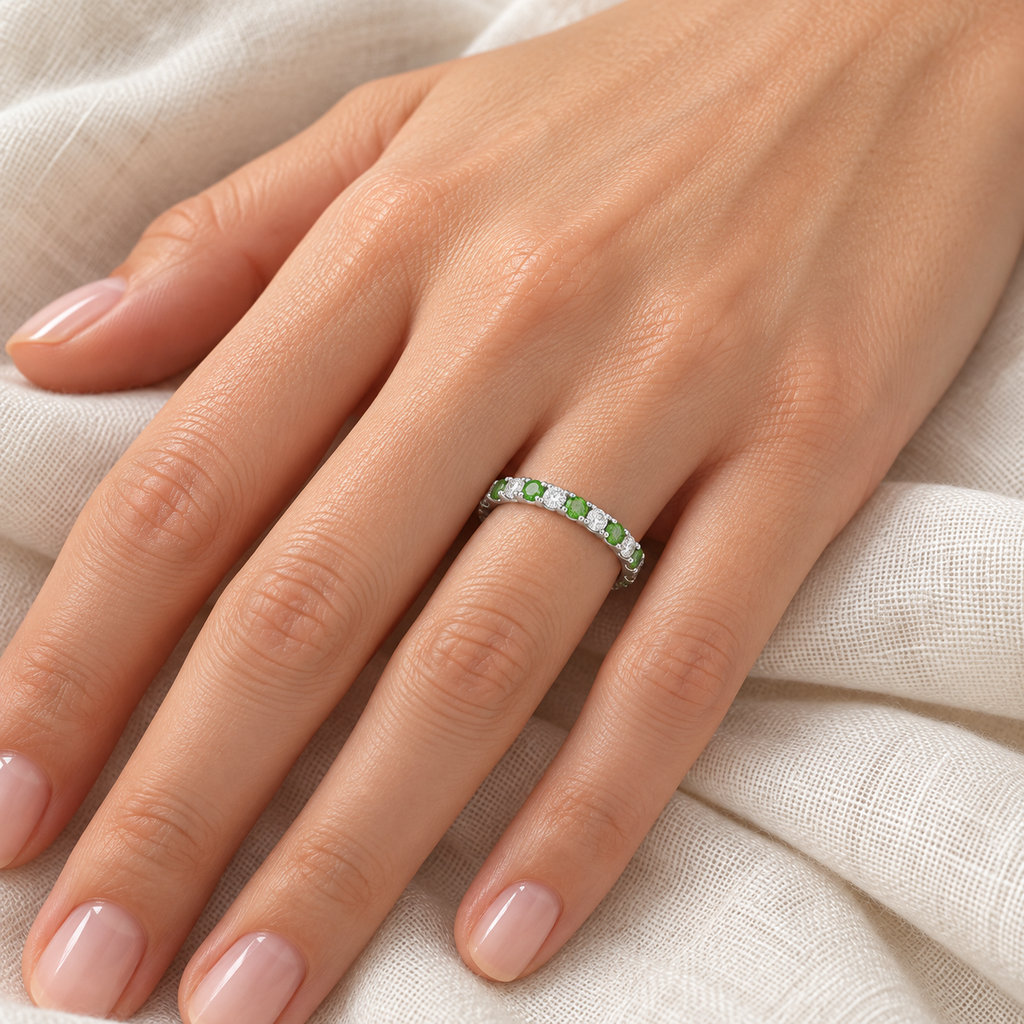 Tsavorite and diamond 14K white gold 2 mm eternity band on left hand, ivory linen closeup