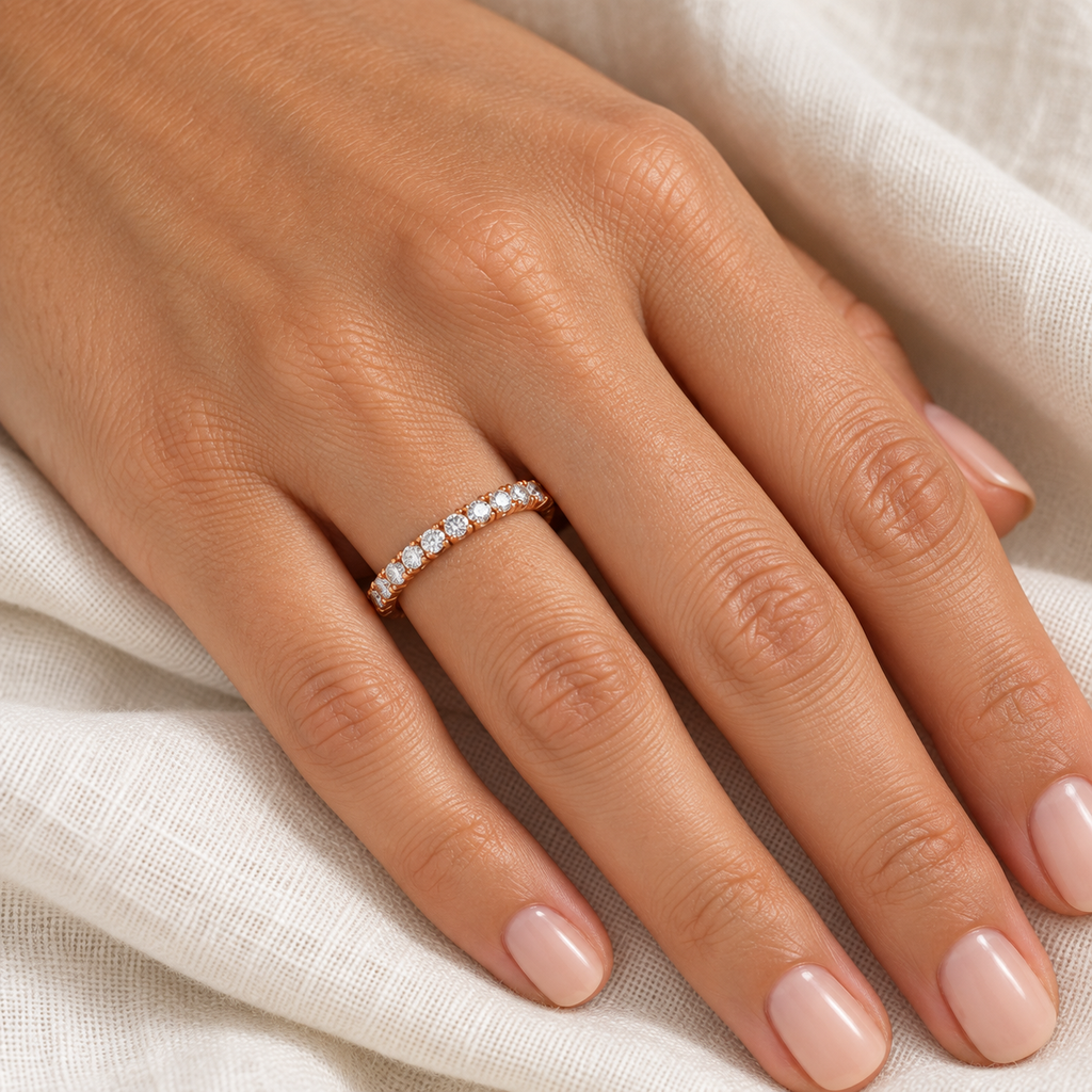 Diamond 14K rose gold 2 mm eternity band on left hand, ivory linen closeup