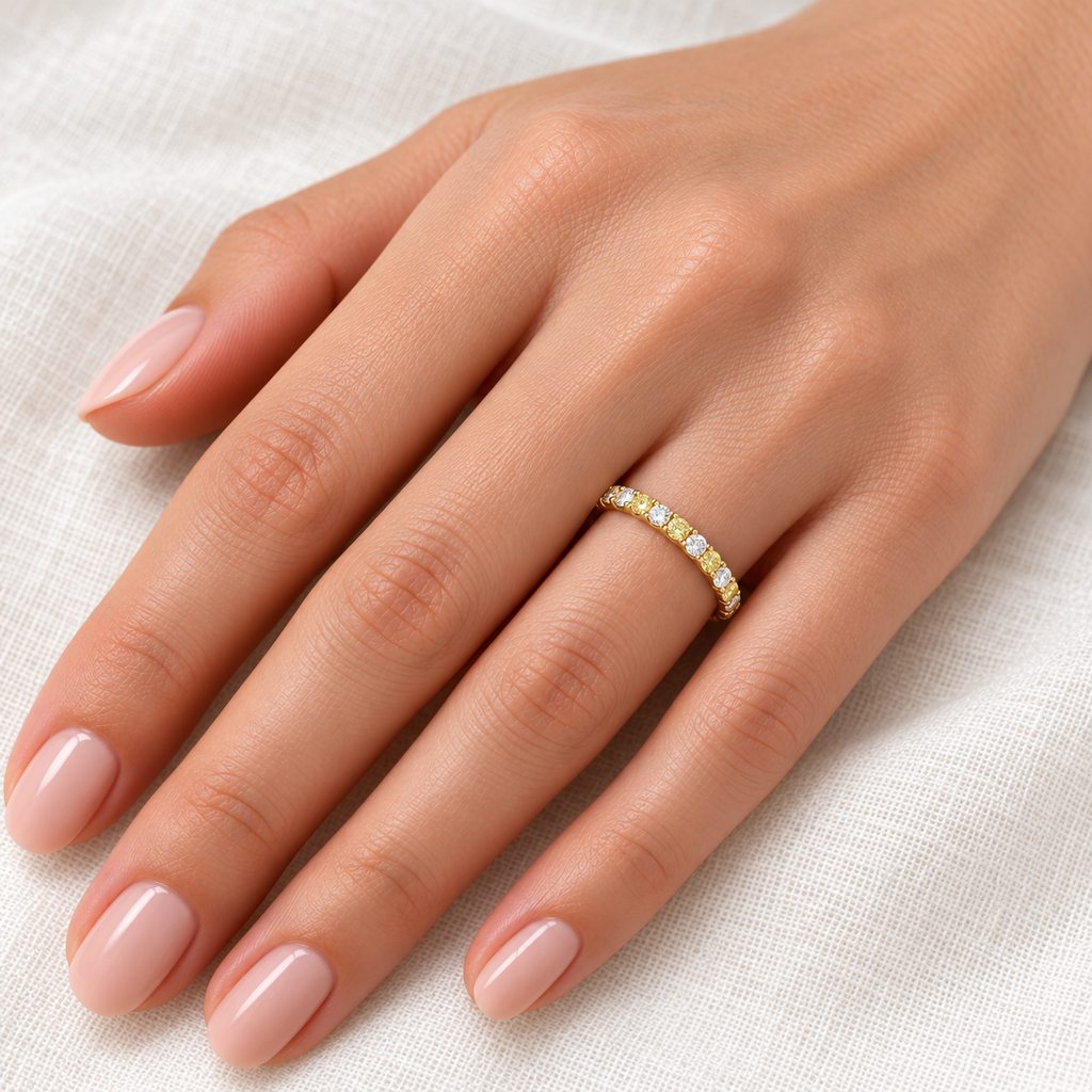 Alternating yellow and white diamond 14K yellow gold 2 mm eternity band on left hand, ivory linen closeup
