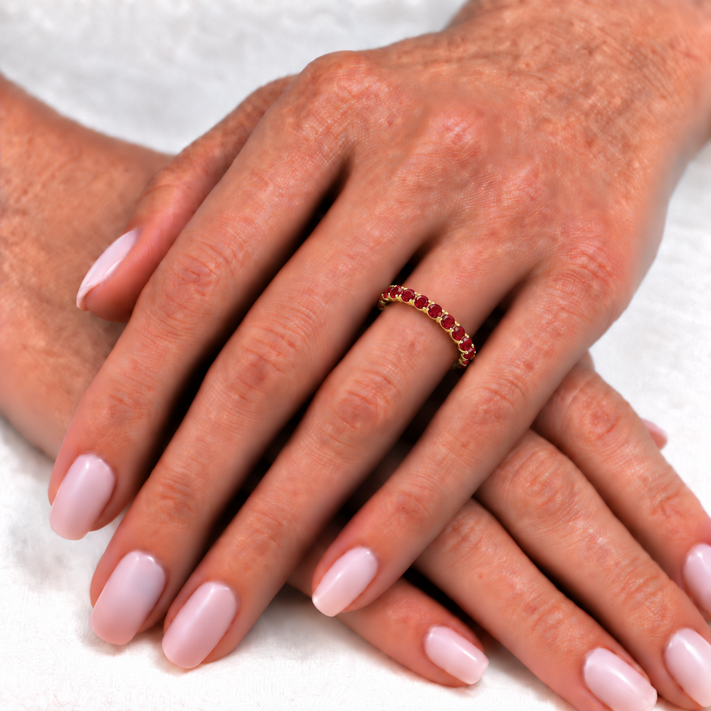 Lab red garnet eternity ring worn on the left hand over soft ivory linen
