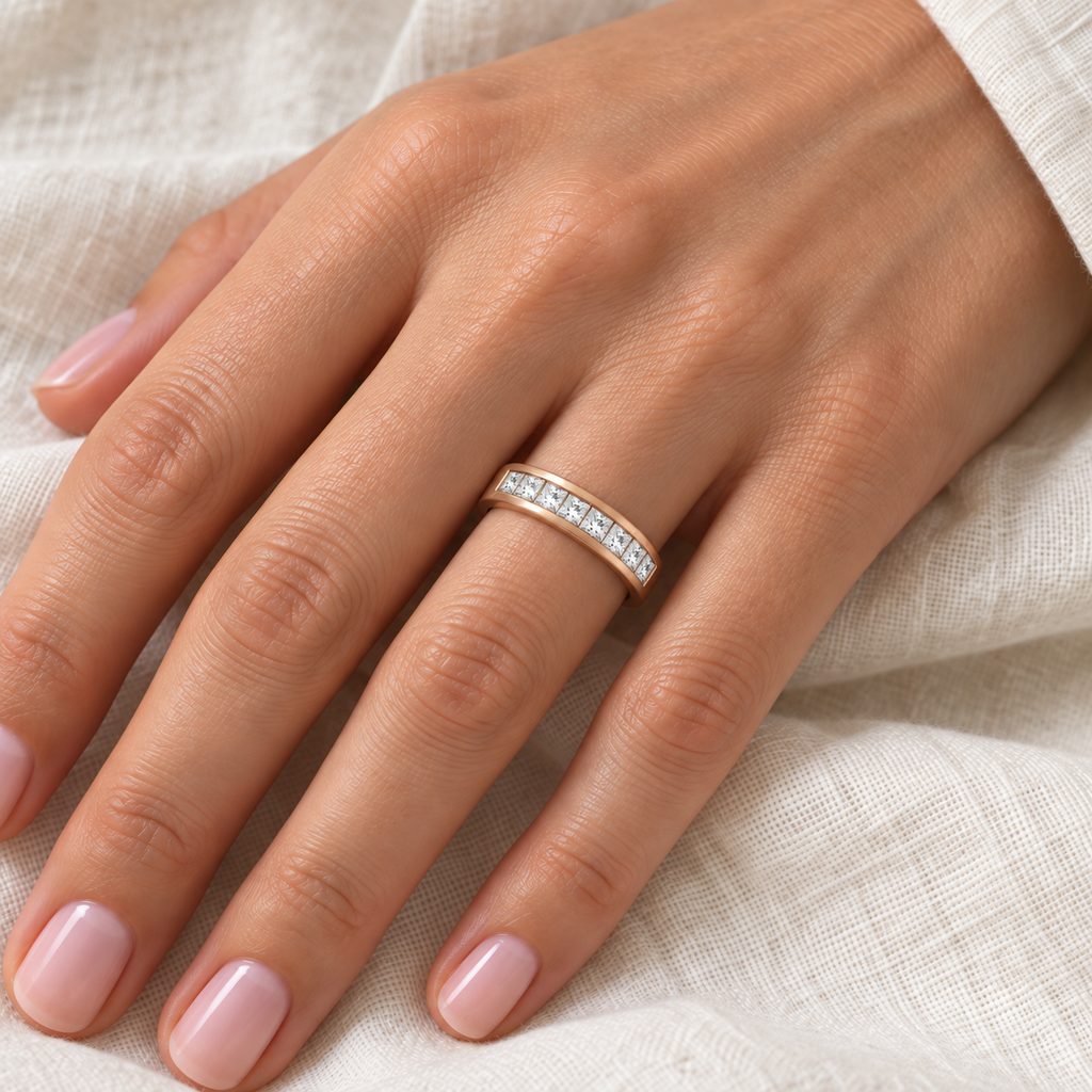 IR177LG 14k rose gold channel-set lab-grown princess-cut diamond band on left ring finger, ivory linen close-up
