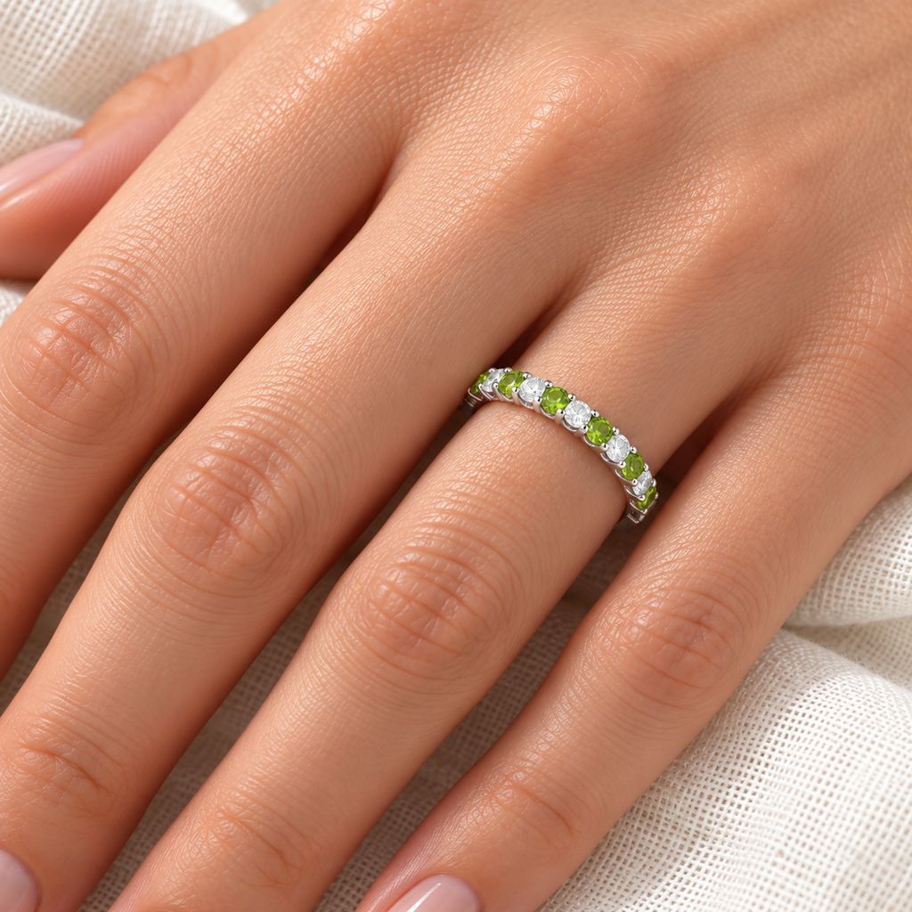 Peridot and diamond anniversary band in 14k white gold on a left hand over ivory linen, 0.50ct