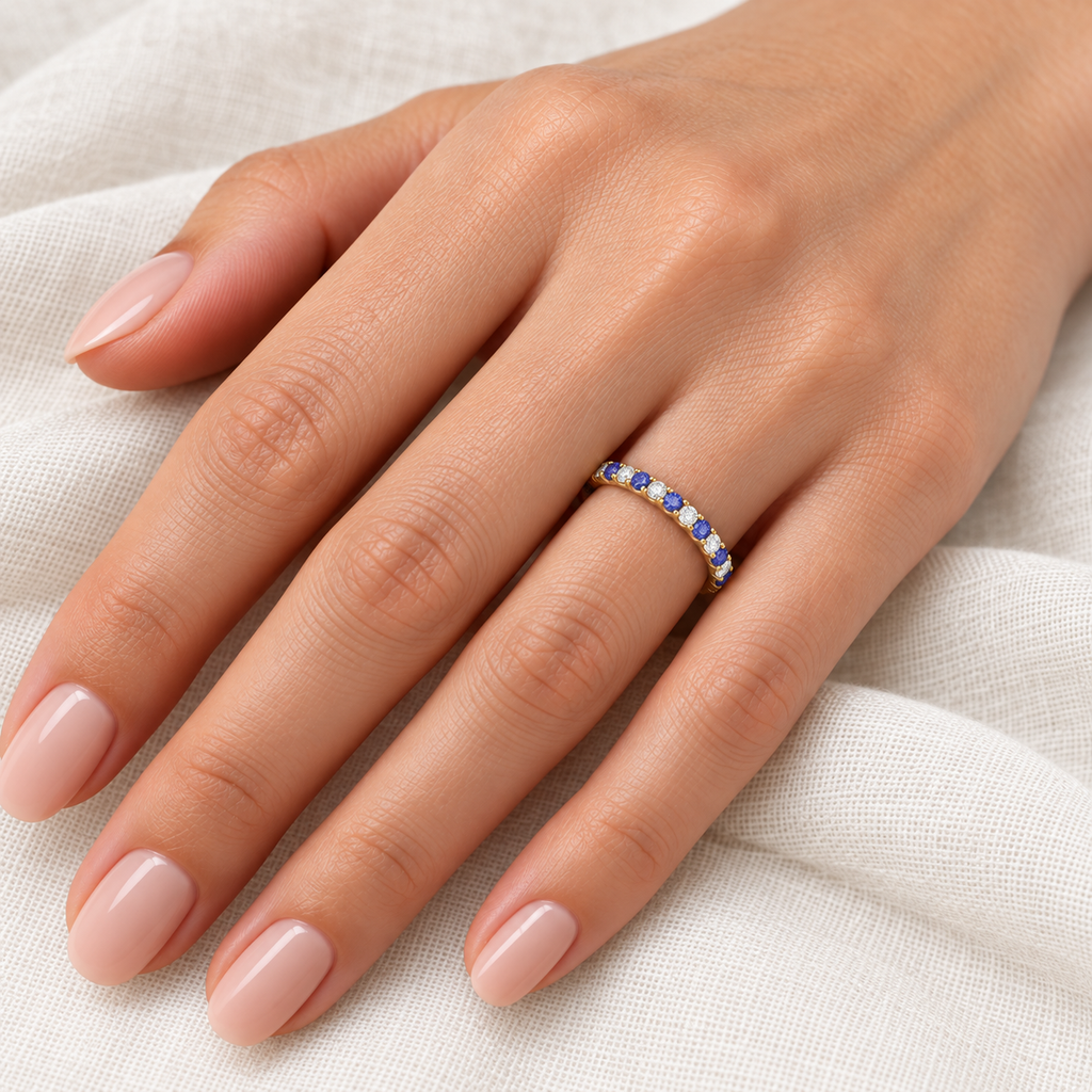 Alternating tanzanite and diamond 14K yellow gold 2 mm eternity band on left hand, ivory linen closeup