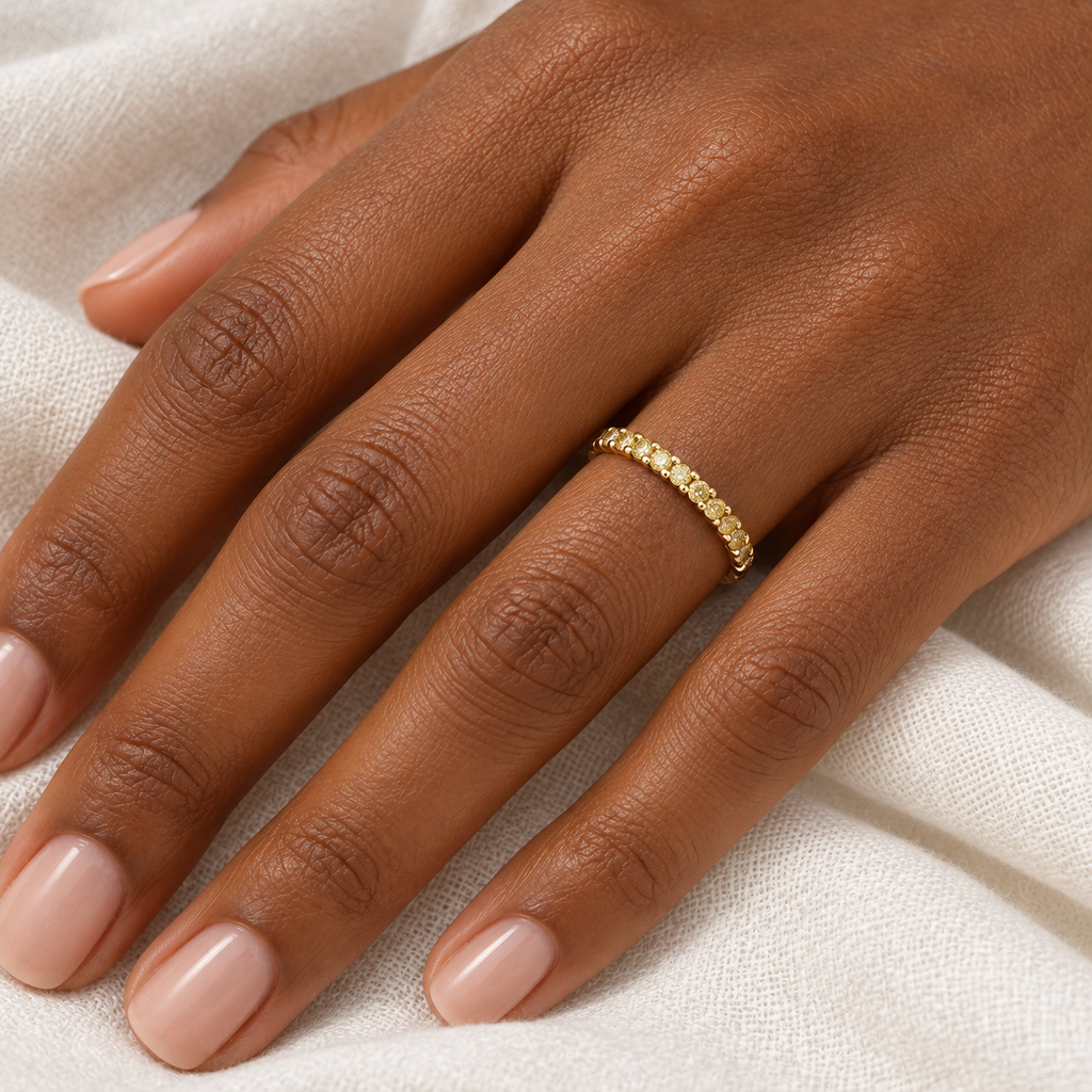 Canary yellow diamond 14K yellow gold 2 mm eternity band on left hand, ivory linen closeup