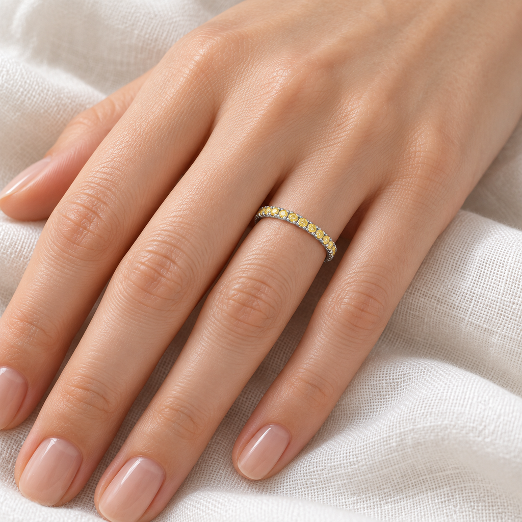 Canary yellow diamond 14K white gold 2 mm eternity band on left hand, ivory linen closeup
