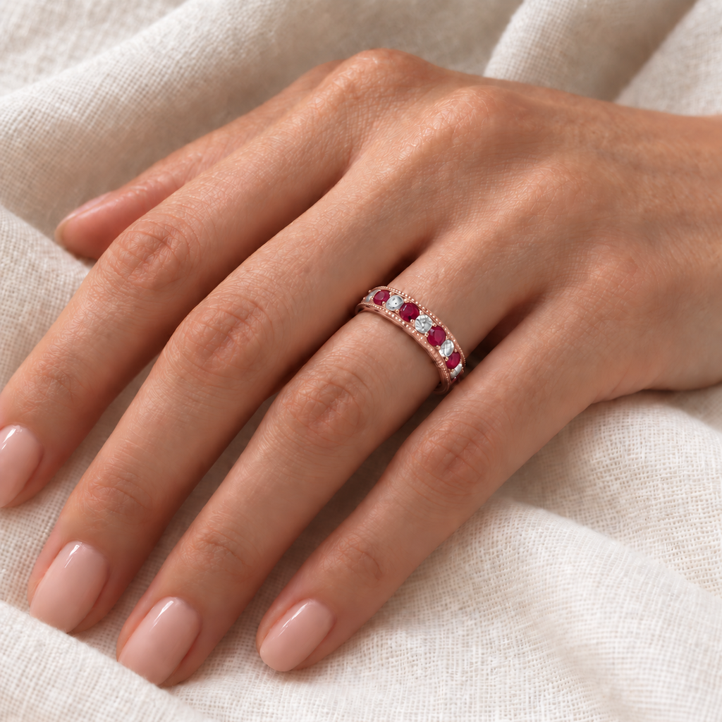 IR2311 natural ruby and diamond anniversary band in 14K rose gold on left hand over ivory linen