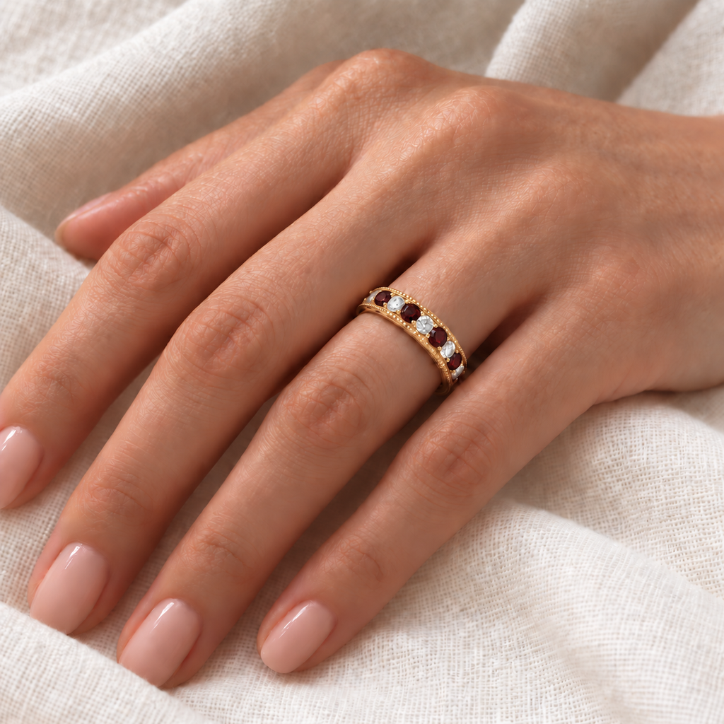 IR2312 natural garnet and diamond anniversary band in 14K yellow gold on left hand over ivory linen