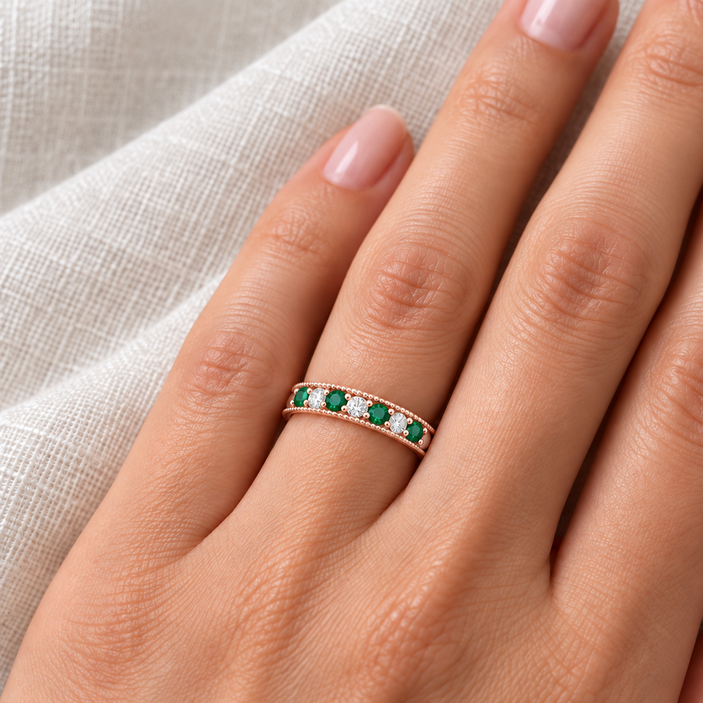Emerald and diamond 3mm rose gold band on left ring finger, ivory linen closeup
