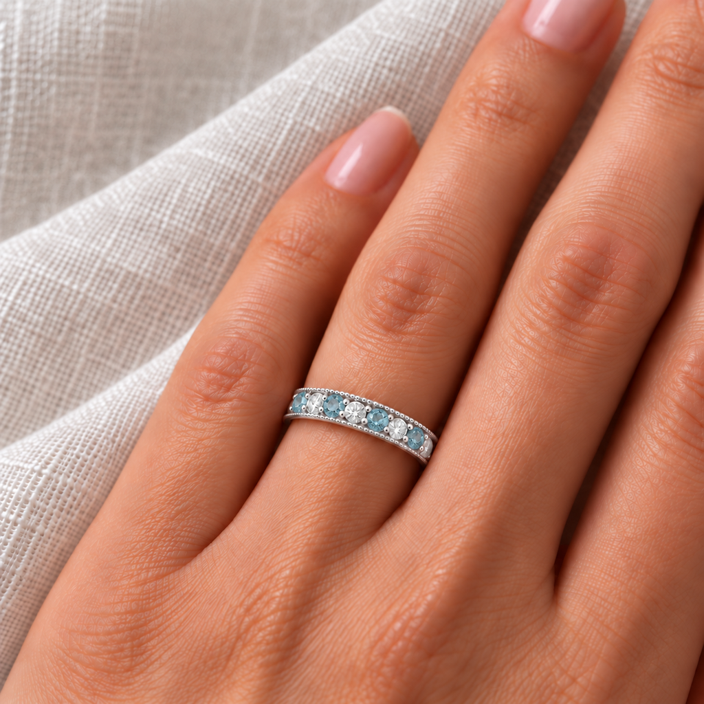 Aquamarine and diamond white gold ring on left hand, ivory linen closeup