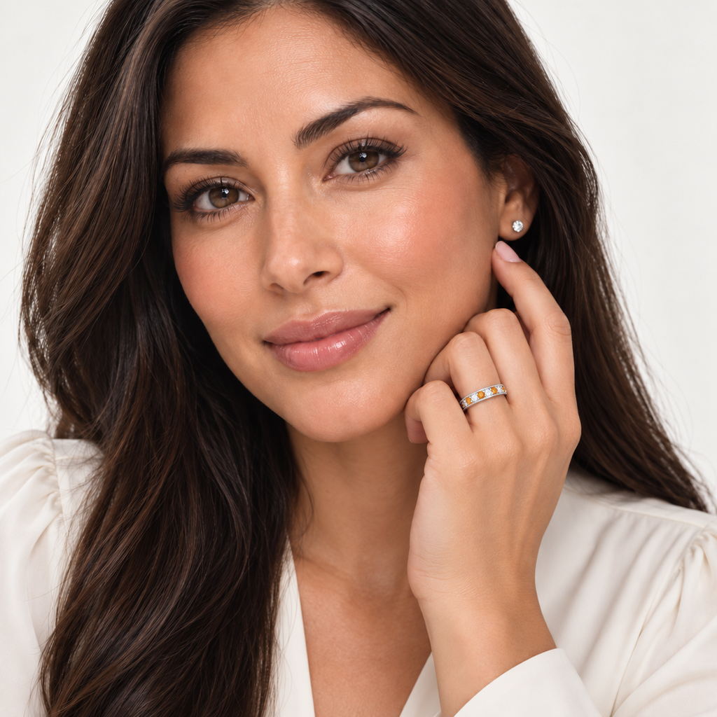 Model wearing citrine and diamond white gold band at base of left ring finger, studio portrait