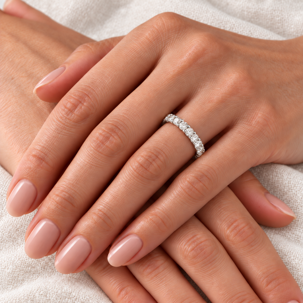 Lab Diamond Eternity Ring Wedding Band in 14k White Gold (2.00ct) — close-up on left ring finger over light ivory linen