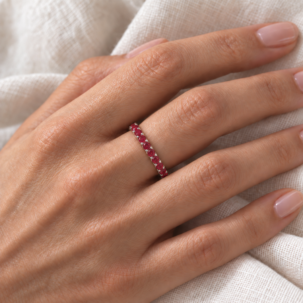 Prong-Set Lab Ruby Eternity Ring Band 14k White Gold (1.07ct) — correctly scaled fine 2.5mm band on left ring finger over ivory linen