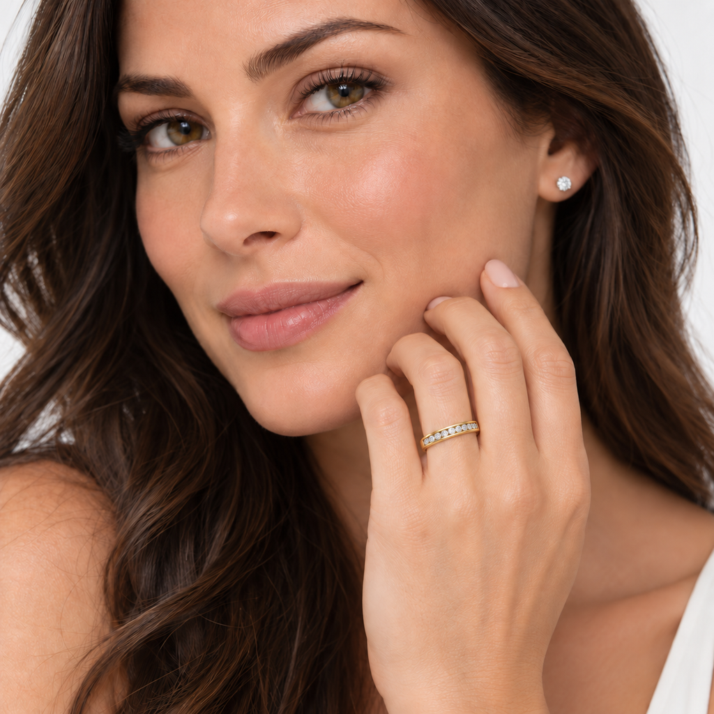 Fine 3 mm channel-set natural diamond band in yellow gold on left ring finger, studio portrait